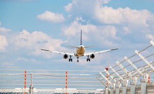 Barbed wired fence with an aircraft landing in the background.jpg