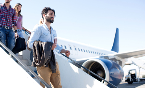 Passengers walking down stairs with aircraft in the background.jpg