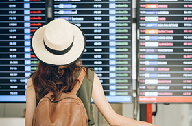 Traveler looking at airport flight schedule screen