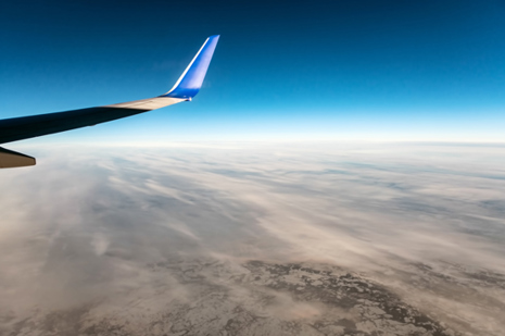 Aicraft wing tip over cloudy landscape